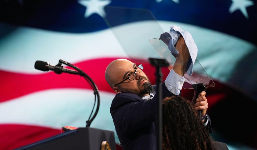 Gabriel Perez cleans the teleprompter before President Donald Trump speaks at the Future Investment Initiative Institute's summit in Miami Beach, Fla., on March 27, 2026. (AP Photo/Mark Schiefelbein) **FILE**
