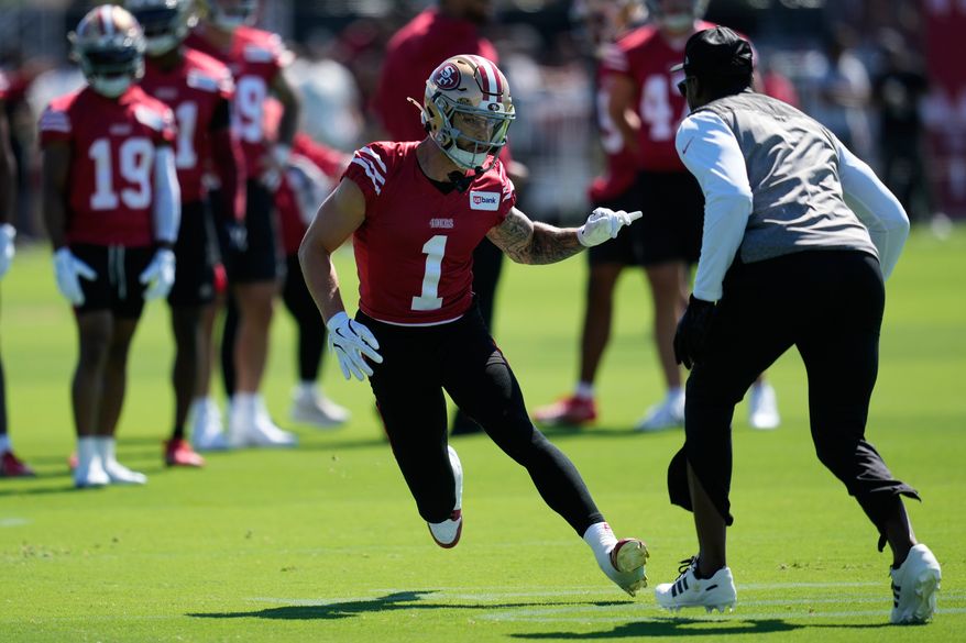 San Francisco 49ers wide receiver Ricky Pearsall (1) runs a drill against wide receivers coach Leonard Hankerson during the NFL football team's training camp Monday, July 27, 2026, in Santa Clara, Calif. (AP Photo/Jeff Chiu)