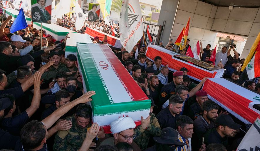 Mourners carry coffins draped in the Iranian flag, foreground, and the Iraqi flag during a group funeral for Iranian advisers and Popular Mobilization Forces fighters killed in airstrikes on bases belonging to Iraq's Popular Mobilization Forces, a coalition of predominantly Shiite militias that includes Iran-backed groups, in Mosul, Iraq, Wednesday, July 29, 2026. (AP Photo/Hadi Mizban)