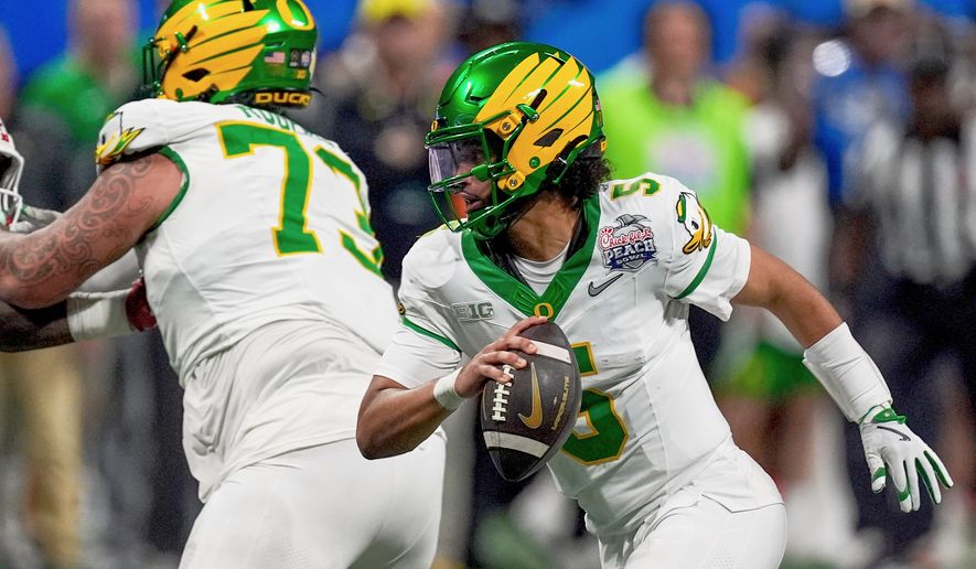 FILE - Oregon quarterback Dante Moore (5) works against Indiana during the second half of the Peach Bowl NCAA college football playoff semifinal, Jan. 9, 2026, in Atlanta. (AP Photo/Mike Stewart, File)