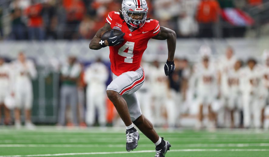 FILE - Ohio State wide receiver Jeremiah Smith runs the ball against Miami during the second half of the Cotton Bowl College Football Playoff quarterfinal game, Dec. 31, 2025, in Arlington, Texas. (AP Photo/Gareth Patterson, File)