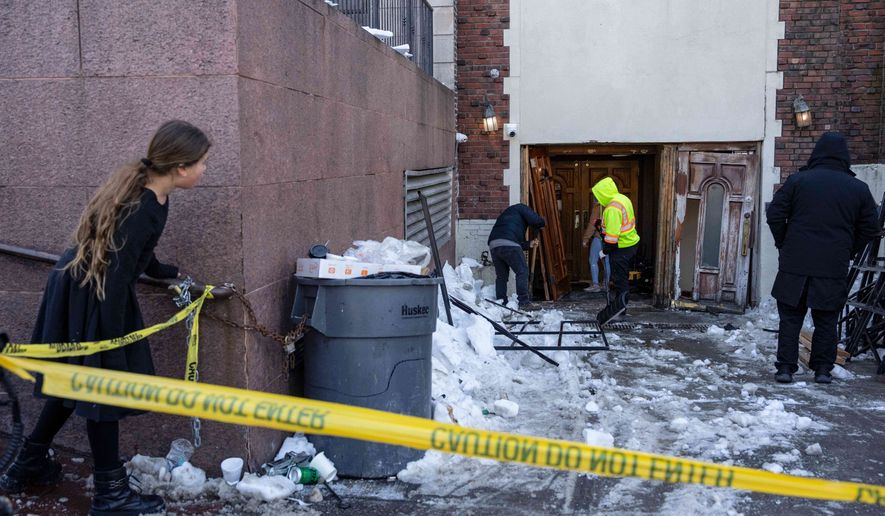 FILE - People clean up after a car slammed into the entrance of the Chabad Lubavitch world headquarters, Jan. 29, 2026, in New York. (AP Photo/Yuki Iwamura, File)