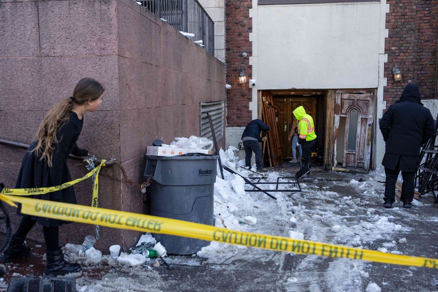FILE - People clean up after a car slammed into the entrance of the Chabad Lubavitch world headquarters, Jan. 29, 2026, in New York. (AP Photo/Yuki Iwamura, File)