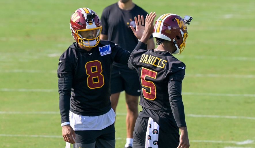Washington Commanders quarterbacks Marcus Mariota (8) and Jayden Daniels (5) work out during practice at the team's NFL football training camp, Wednesday, July 29, 2026, in Ashburn, Va. (AP Photo/Rod Lamkey, Jr.)