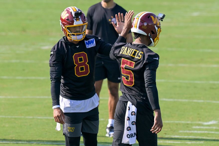 Washington Commanders quarterbacks Marcus Mariota (8) and Jayden Daniels (5) work out during practice at the team's NFL football training camp, Wednesday, July 29, 2026, in Ashburn, Va. (AP Photo/Rod Lamkey, Jr.)