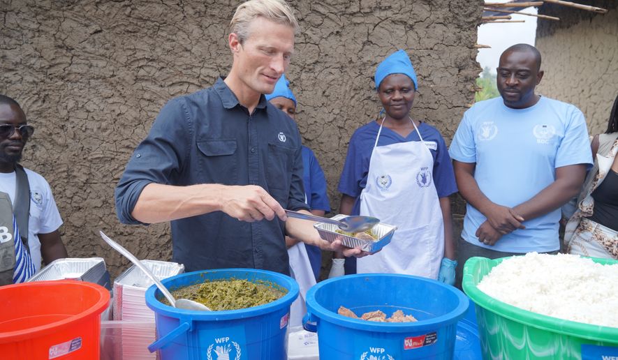 Carl Skau, acting executive director of the World Food Programme, pepares a container of food at the Rwampara Ebola treatment center in Ituri, eastern Congo, Wednesday, July 29, 2026. (AP Photo/Dieudonne Dirole)