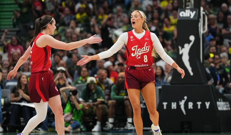 Indiana Fever guard Caitlin Clark, left, greets guard Sophie Cunningham (8) after Cunningham made a basket against the Seattle Storm during the first half of a WNBA basketball game, Tuesday, July 28, 2026, in Seattle. (AP Photo/Lindsey Wasson)