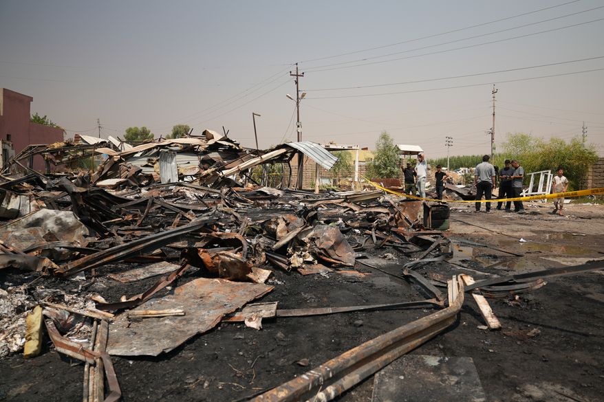Iraqis inspect damaged structures at the site of an airstrike on a Popular Mobilization Forces base in Mosul, Iraq, Wednesday, July 29, 2026. (AP Photo/Farid Abdulwahed)