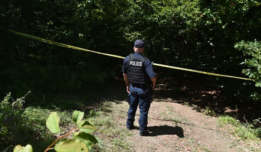 Kosovo policeman guards the site where forensic teams have begun excavations of a mass grave near the village of Kalluder, Wednesday, July 29, 2026. (AP Photo/Florent Bajrami)