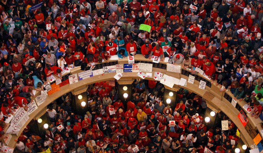 FILE - Protestors of Wisconsin Gov. Scott Walker's bill to eliminate collective bargaining rights for many state workers pack the rotunda at the State Capitol Feb. 17, 2011, in Madison, Wis. (AP Photo/Andy Manis, File)