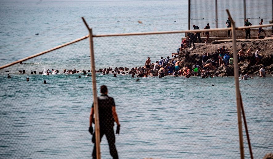 Migrants cross from Morocco into the Spanish enclave of Ceuta, Thursday, July 30, 2026. (AP Photo/Antonio Sempere)
