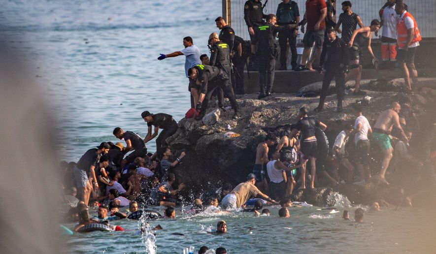 Migrants try to cross from Morocco into the Spanish enclave of Ceuta, Thursday, July 30, 2026. (AP Photo/Antonio Sempere)