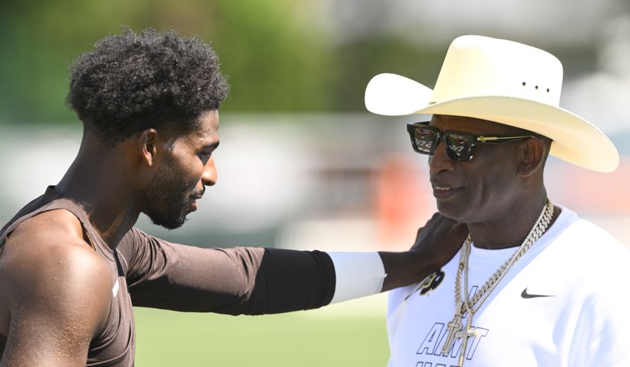 Cleveland Browns quarterback Shedeur Sanders, left, talks with his father and NFL Hall of Fame member Deion Sanders after the team's NFL football training camp, Thursday, July 30, 2026, in Berea, Ohio. (AP Photo/David Richard)