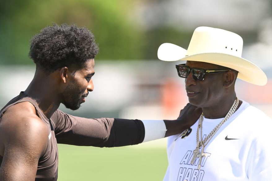 Cleveland Browns quarterback Shedeur Sanders, left, talks with his father and NFL Hall of Fame member Deion Sanders after the team's NFL football training camp, Thursday, July 30, 2026, in Berea, Ohio. (AP Photo/David Richard)