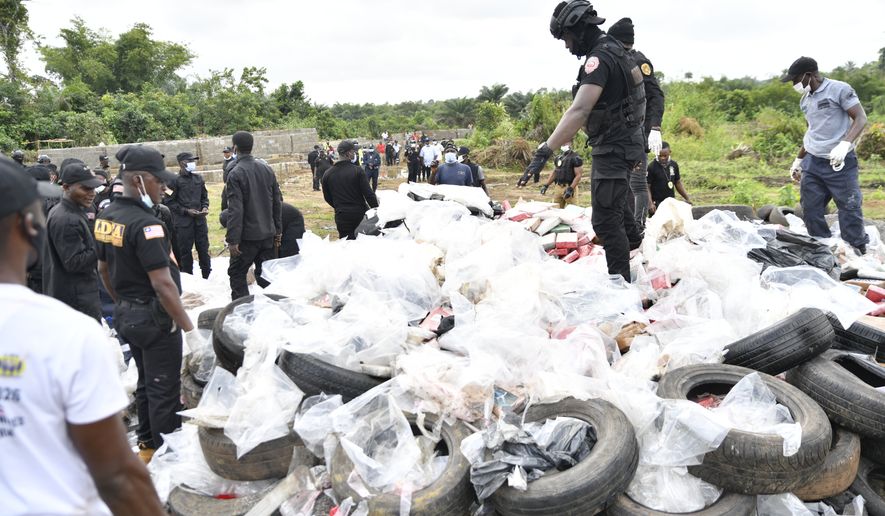 Liberian law enforcement agency officials prepare to burn cocaine consignments in Caraysburg in the outskirts of Monrovia, Liberia, Thursday, July 30, 2026. (AP Photo/Alexander Wiaplah)