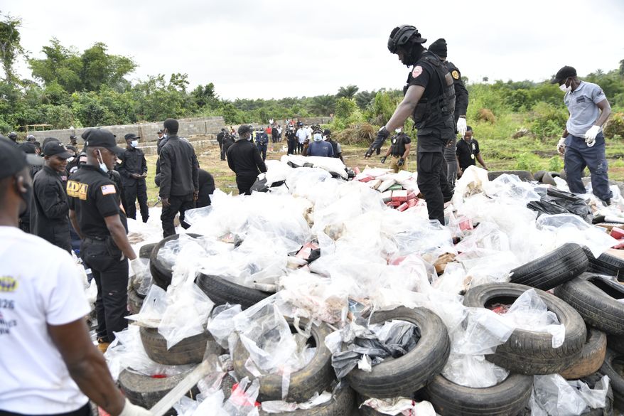 Liberian law enforcement agency officials prepare to burn cocaine consignments in Caraysburg in the outskirts of Monrovia, Liberia, Thursday, July 30, 2026. (AP Photo/Alexander Wiaplah)