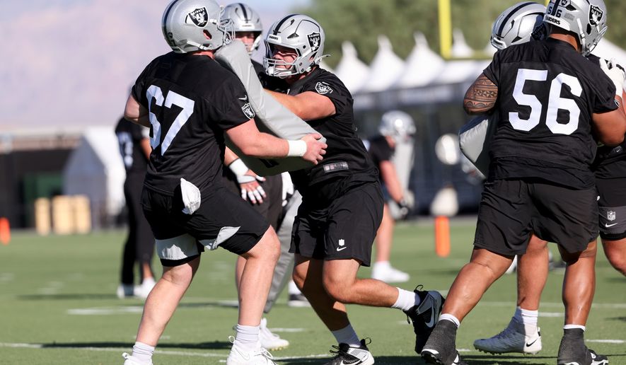 Las Vegas Raiders center Tyler Linderbaum (65) blocks center Will Putnam (67) during a drill during practice at the team's NFL football training camp, Thursday, July 30, 2026, in Henderson, Nev. (AP Photo/Ian Maule)