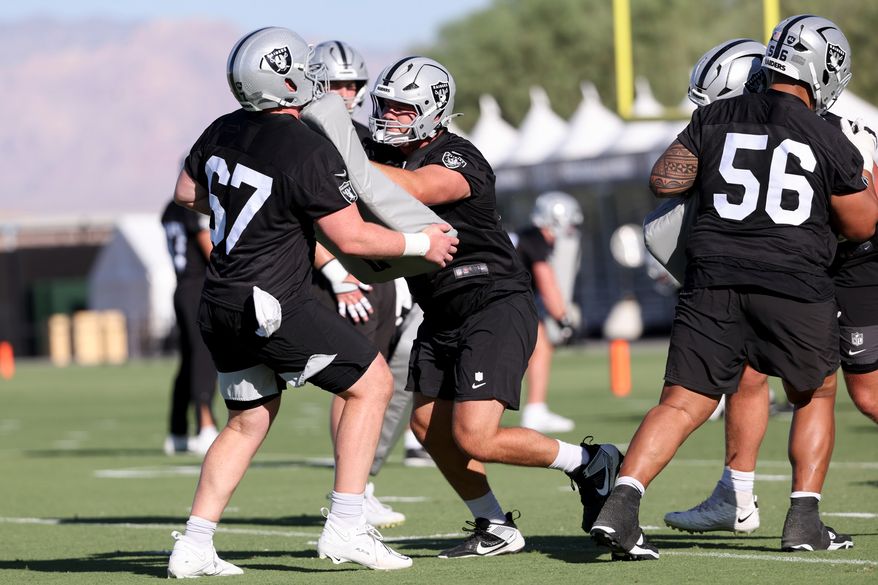 Las Vegas Raiders center Tyler Linderbaum (65) blocks center Will Putnam (67) during a drill during practice at the team's NFL football training camp, Thursday, July 30, 2026, in Henderson, Nev. (AP Photo/Ian Maule)