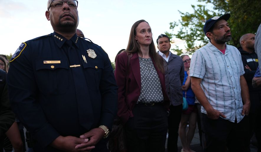 Seattle Mayor Katie Wilson, center, and Seattle Police Chief Shon Barnes, left, attend the vigil for victims the day after a shooting at Seattle Center during the Bite of Seattle food festival, Monday, July 27, 2026, in Seattle. (AP Photo/Lindsey Wasson)