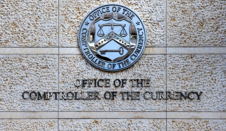 FILE - The official seal of the Office of the Comptroller of the Currency is seen on an office building in Washington, Feb. 13, 2026. (AP Photo/Cliff Owen, File)