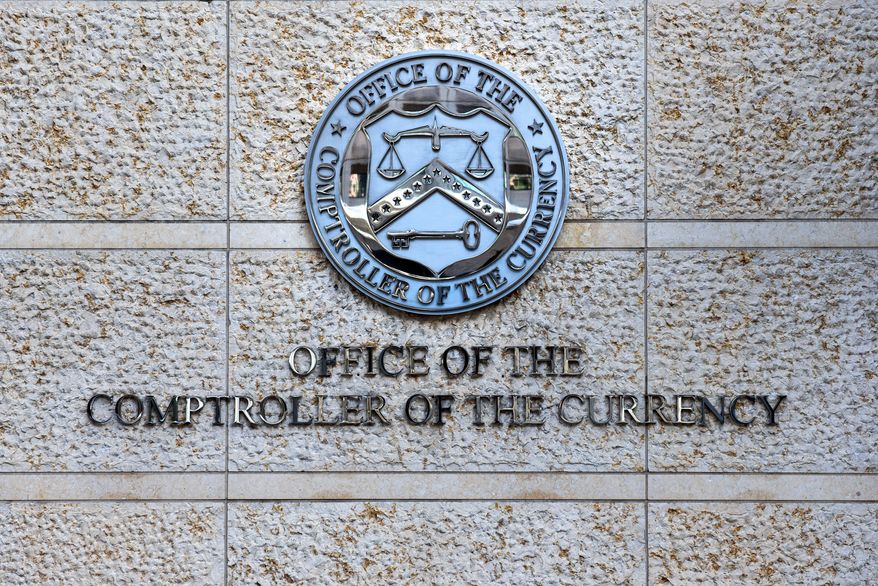FILE - The official seal of the Office of the Comptroller of the Currency is seen on an office building in Washington, Feb. 13, 2026. (AP Photo/Cliff Owen, File)