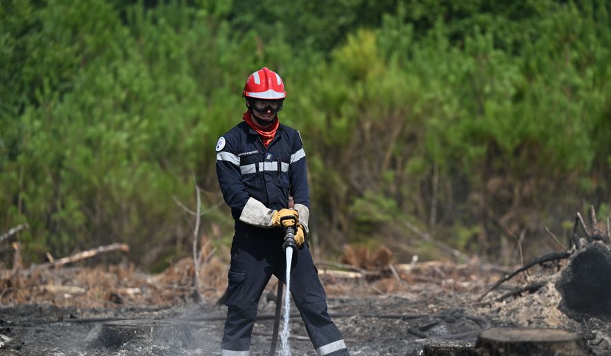 A firefighter works to extinguished fires near Lege-Cap-Ferret, southwestern France, Friday, July 31, 2026. (AP Photo/Emma Da Silva)