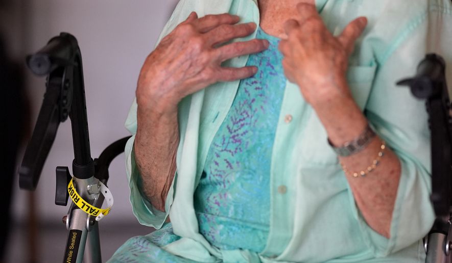 A "fall risk" alert bracelet marks the walker of Anna Fischbein as she speaks about the loss of a beloved Haitian home health care worker whose Temporary Protected Status expired this week, during an interview in her apartment, Thursday, July 30, 2026, in Sunny Isles Beach, Fla. (AP Photo/Rebecca Blackwell).