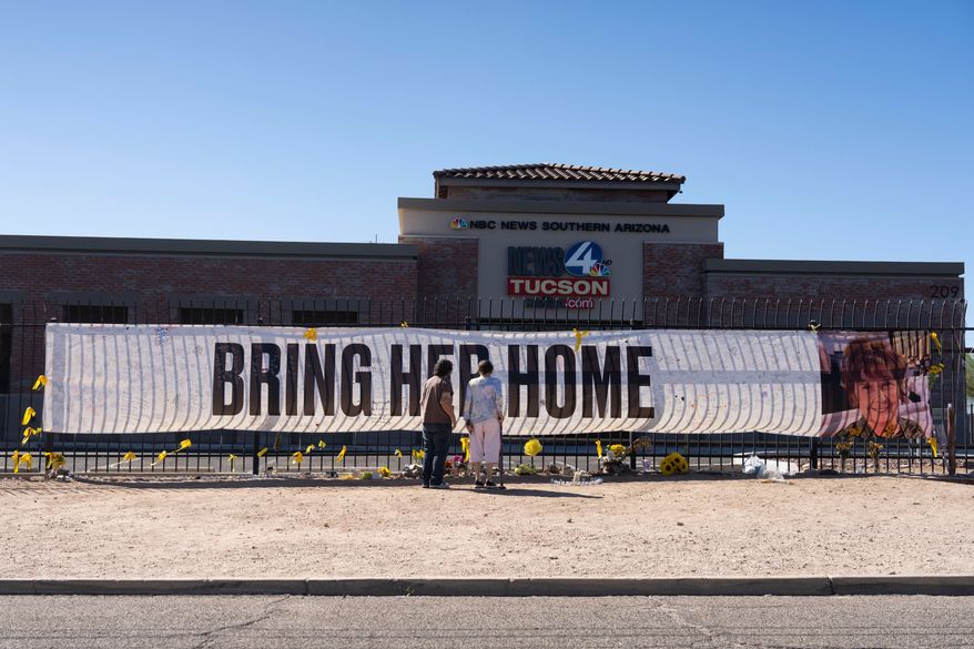 People visit a banner for Nancy Guthrie, the missing mother of "Today" show host Savannah Guthrie, outside the KVOA Newsroom in Tucson, Ariz., on March 6, 2026. (AP Photo/Rebecca Noble, File)