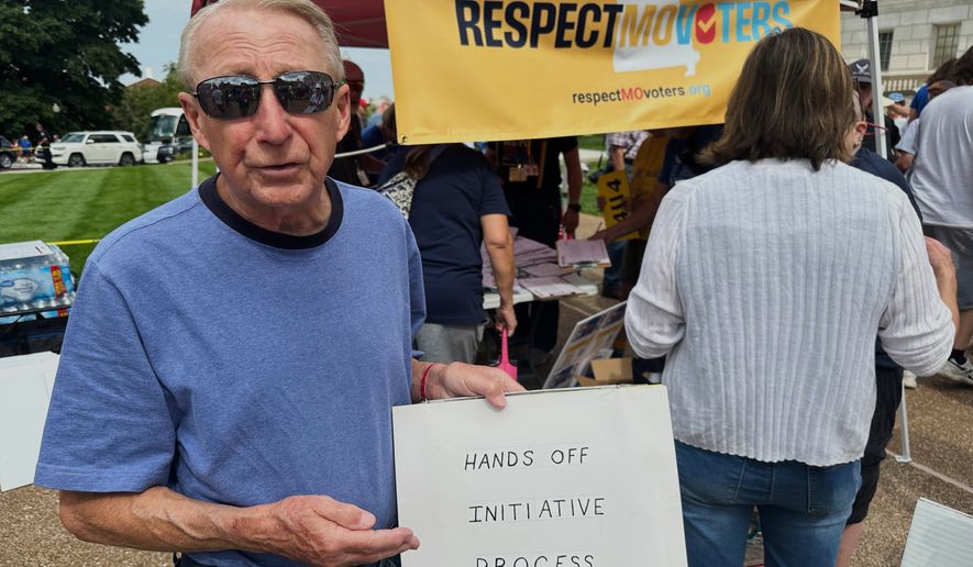FILE - John Billman, of Columbia, Mo., holds a sign explaining his opposition to a state legislative proposal that would make it harder for voters to approve citizen-initiated constitutional amendments while rallying at the state Capitol in Jefferson City, on Wednesday, Sept. 10, 2025. (AP Photo/David A. Lieb, File)