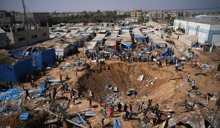 Palestinians inspect the scene of an Israeli airstrike near al-Aqsa Hospital in Deir al-Balah in the central Gaza Strip, Saturday, Aug. 1, 2026. (AP Photo/Abdel Kareem Hana)
