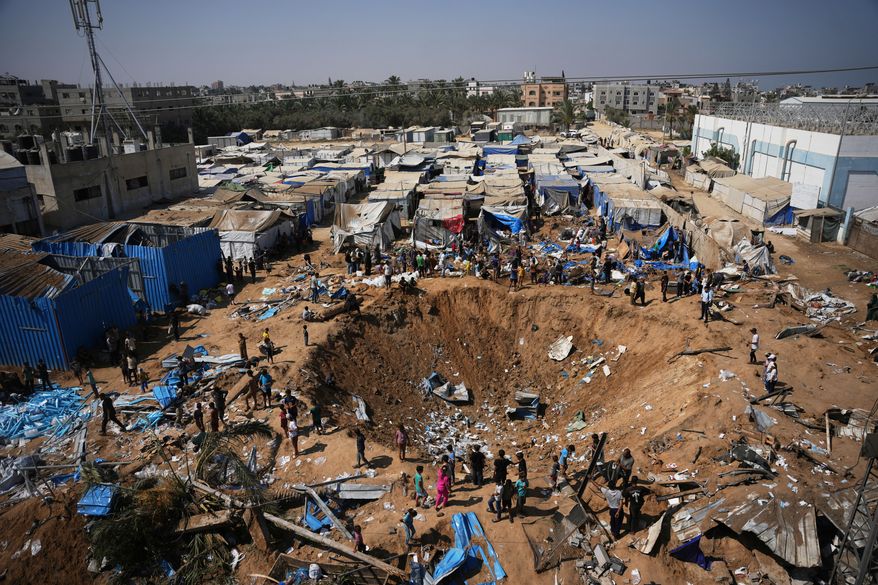 Palestinians inspect the scene of an Israeli airstrike near al-Aqsa Hospital in Deir al-Balah in the central Gaza Strip, Saturday, Aug. 1, 2026. (AP Photo/Abdel Kareem Hana)