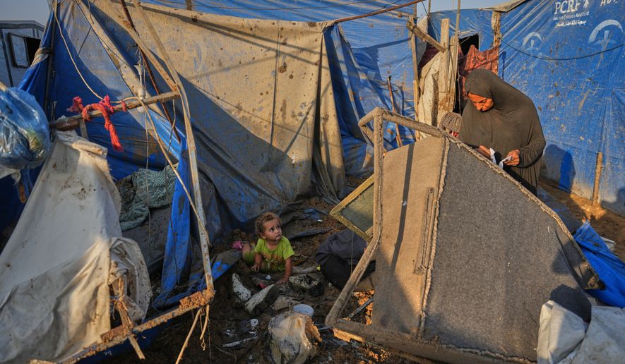 A Palestinian woman inspects the scene of an Israeli airstrike near al-Aqsa Hospital in Deir al-Balah in the central Gaza Strip, Saturday, Aug. 1, 2026. (AP Photo/Abdel Kareem Hana)