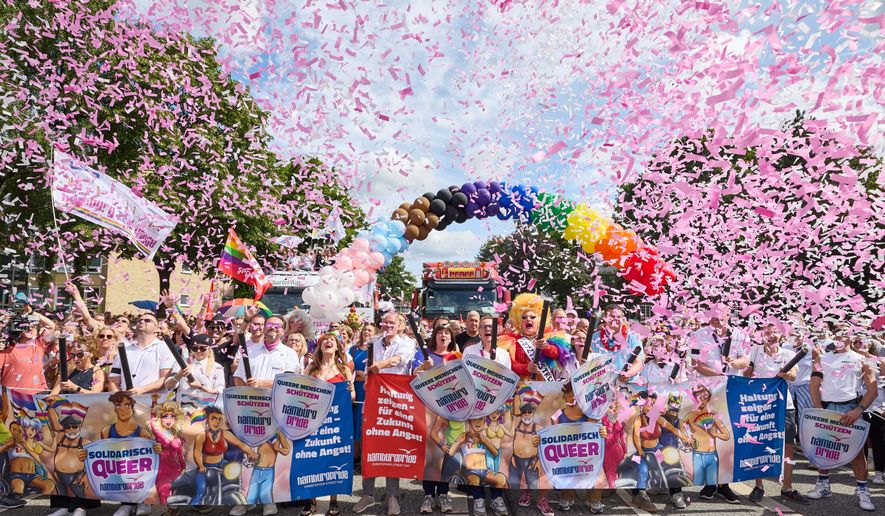 Under the rainbow, from left to right: Member of the Bundestag; Matthias Miersch (SPD), Chair of the SPD parliamentary group in the Bundestag; Katharina Fegebank (Greens), Second Mayor of Hamburg; Oliver Greve, Hamburg Pride e.V.; and Olivia Jones, drag queen; along with other participants, stand on Luebecker Strase at the start of the Hamburg Pride 2026 parade for Christopher Street Day (CSD), in Hamburg, Germany, Saturday Aug. 1, 2026. (Georg Wendt/dpa via AP)