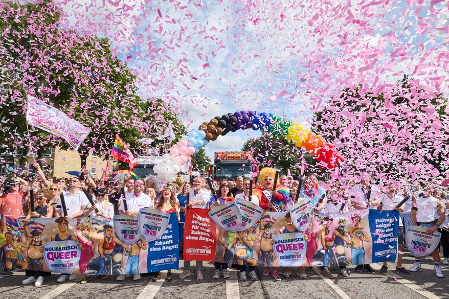 Under the rainbow, from left to right: Member of the Bundestag; Matthias Miersch (SPD), Chair of the SPD parliamentary group in the Bundestag; Katharina Fegebank (Greens), Second Mayor of Hamburg; Oliver Greve, Hamburg Pride e.V.; and Olivia Jones, drag queen; along with other participants, stand on Luebecker Strase at the start of the Hamburg Pride 2026 parade for Christopher Street Day (CSD), in Hamburg, Germany, Saturday Aug. 1, 2026. (Georg Wendt/dpa via AP)