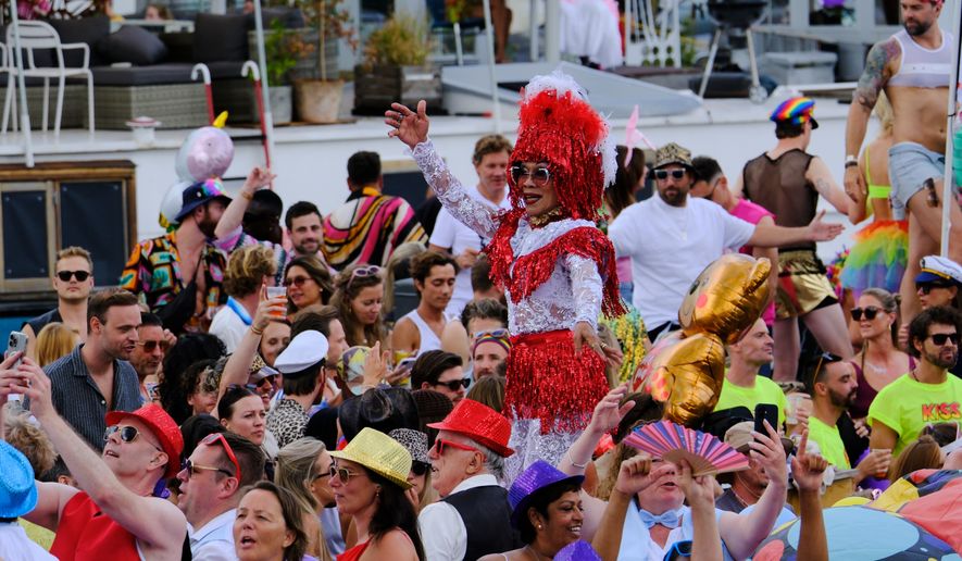 People celebrate atop a boat on one of the Dutch capital's historic canals, Saturday, Aug. 1, 2026, during the Canal Parade, the most popular event of the Pride Amsterdam festival. (AP Photo/Patrick Post)