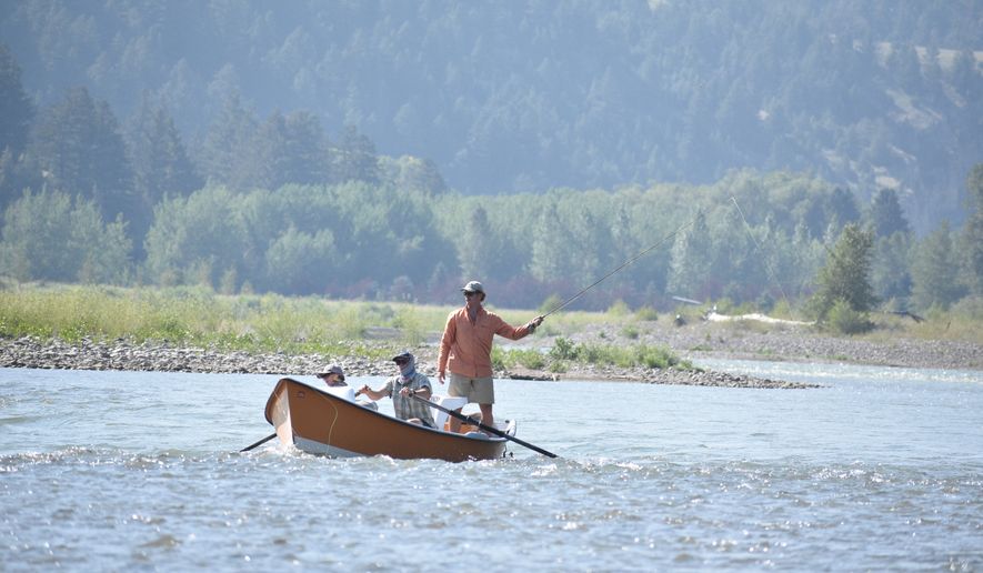 A drift boat with people fly fishing floats down the Yellowstone River, Friday, July 31, 2026, near Livingston, Montana. (AP Photo/Matthew Brown)