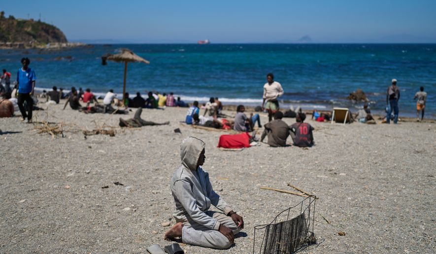 A migrant who crossed into Spain from Morocco prays on a beach in the Spanish enclave of Ceuta, Sunday, Aug. 2, 2026. (AP Photo/Bernat Armangue)