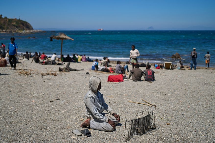 A migrant who crossed into Spain from Morocco prays on a beach in the Spanish enclave of Ceuta, Sunday, Aug. 2, 2026. (AP Photo/Bernat Armangue)