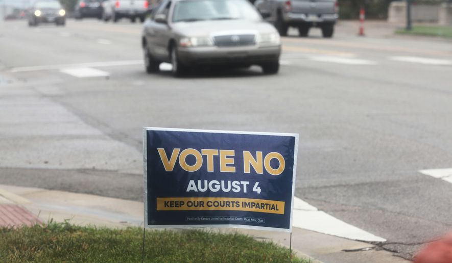 A sign encourages voters to reject a proposal to change how Kanas Supreme Court justices are seated in Topeka, Kan., on Thursday, July 30, 2026. (AP Photo/John Hanna)