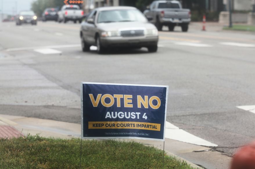 A sign encourages voters to reject a proposal to change how Kanas Supreme Court justices are seated in Topeka, Kan., on Thursday, July 30, 2026. (AP Photo/John Hanna)