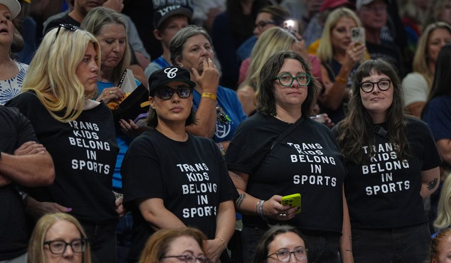 Fans wear shirts saying "Trans Kids Belong In Sports" during a WNBA basketball game between the Minnesota Lynx and the Indiana Fever Sunday, Aug. 2, 2026, in Minneapolis. (AP Photo/Abbie Parr)