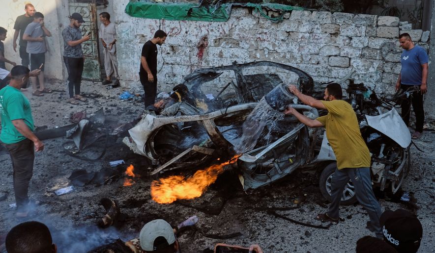 EDS NOTE: GRAPHIC CONTENT - Palestinians try to extinguish a burning car after an Israeli military strike in Gaza City, Sunday, Aug. 2, 2026. (AP Photo/Jehad Alshrafi)