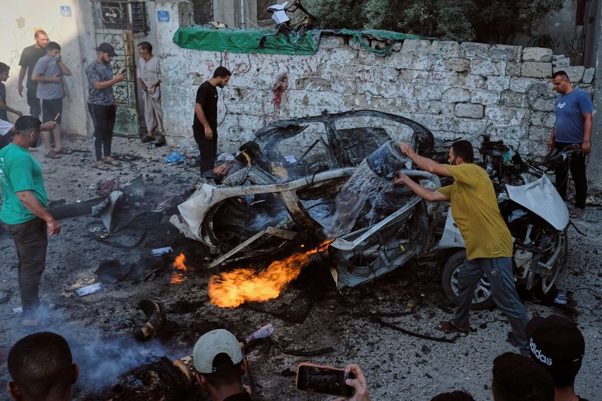 EDS NOTE: GRAPHIC CONTENT - Palestinians try to extinguish a burning car after an Israeli military strike in Gaza City, Sunday, Aug. 2, 2026. (AP Photo/Jehad Alshrafi)