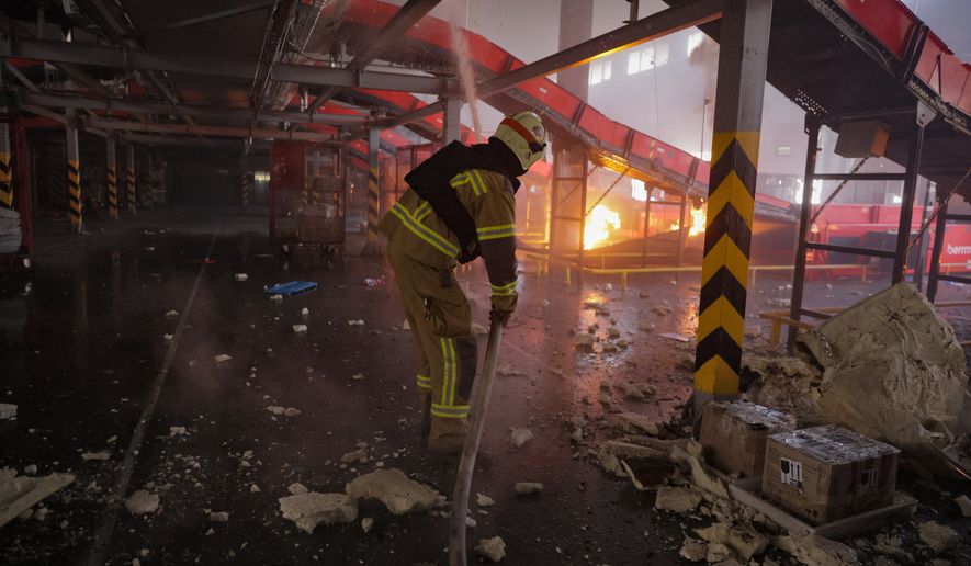 Firefighter put out a fire at a Nova Poshta postal warehouse following Russian air attack on the outskirts of Kharkiv, Ukraine, Sunday, Aug. 2, 2026. (AP Photo/Yevhen Titov)