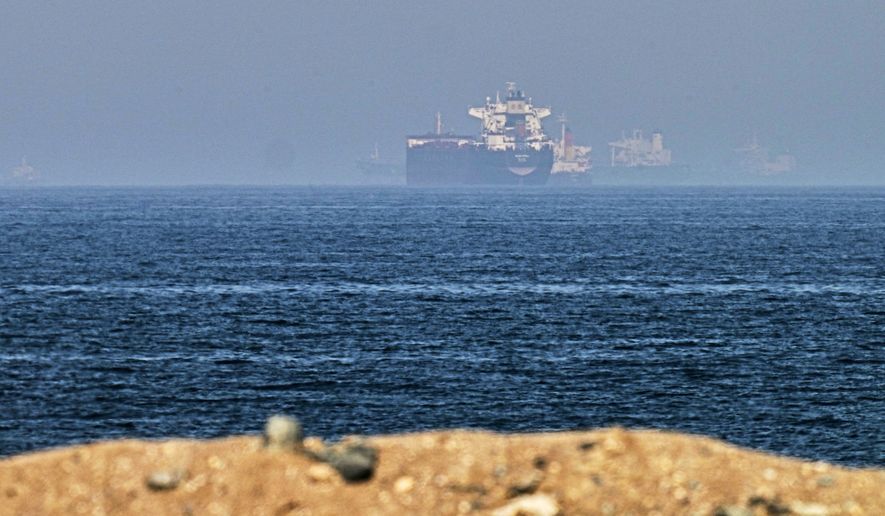 Cargo ships are seen at sea near the Strait of Hormuz, as viewed from a rocky shoreline near Khor Fakkan, United Arab Emirates, Friday, May 1, 2026. (AP Photo/Fatima Shbair, File)