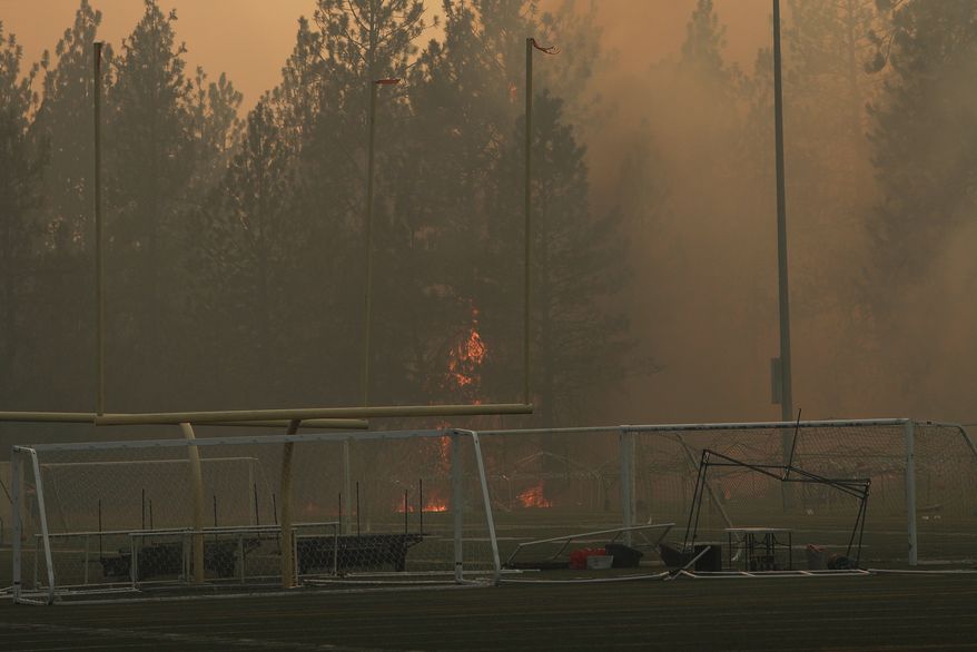 Old Trails Fire burns near Dwight Merkel Sports Complex, Saturday, Aug. 1, 2026, in Spokane, Wash. (AP Photo/Young Kwak)