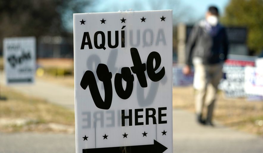 FILE - A man passes an early voting poll site, Feb. 14, 2022, in San Antonio. (AP Photo/Eric Gay, File)