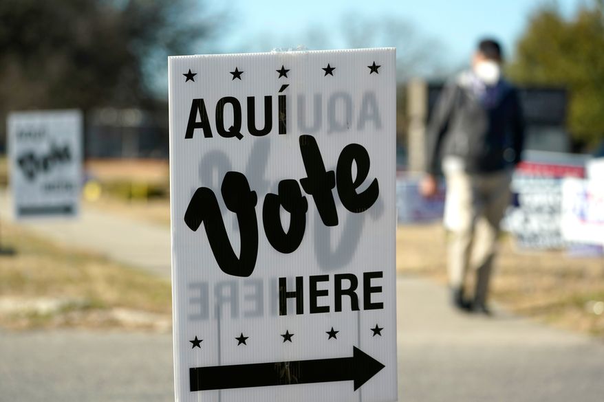 FILE - A man passes an early voting poll site, Feb. 14, 2022, in San Antonio. (AP Photo/Eric Gay, File)