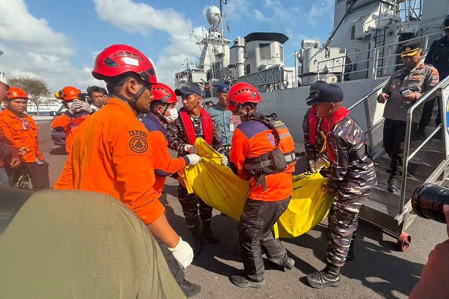 In this photo released by the Indonesian National Search and Rescue Agency (BASARNAS), rescuers carry the body of a victim of a ferry fire upon arrival at Indonesian Navy's 2nd Fleet's pier in Surabaya, East Java, Indonesia, Monday, Aug. 3, 2026. (BASARNAS via AP)