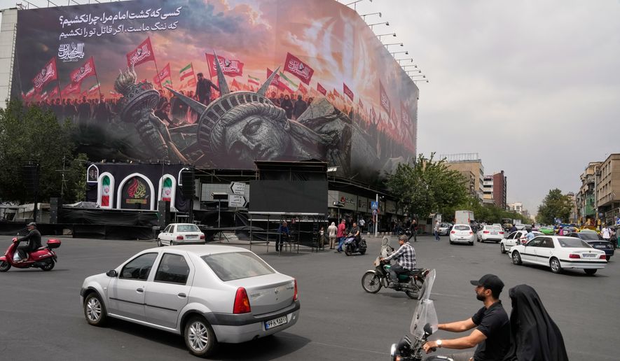 A billboard depicting a fallen Statue of Liberty and crowds carrying Iranian and Shiite flags overlooks Revolution Square in Tehran, Iran, Monday, Aug. 3, 2026. (AP Photo/Vahid Salemi)